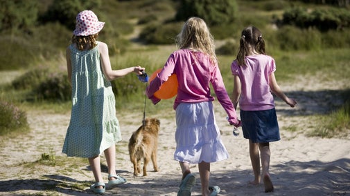 Children walk their dog through the nature reserve at Studland, Dorset